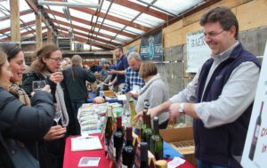 A man pouring wine at a cold weather event.